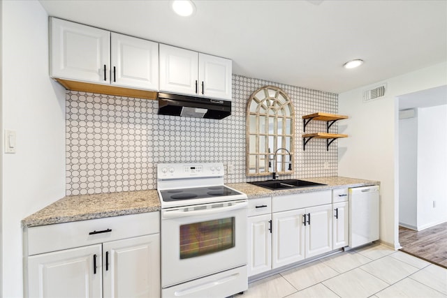 kitchen with white appliances, white cabinetry, sink, and decorative backsplash