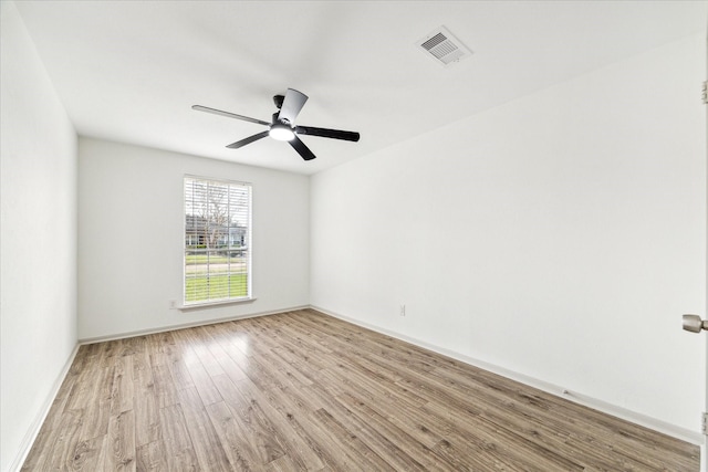 empty room with ceiling fan and light hardwood / wood-style flooring