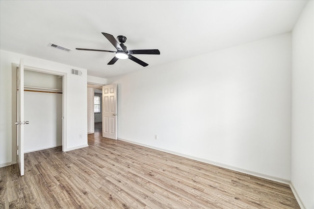 unfurnished bedroom with ceiling fan, light hardwood / wood-style floors, and a closet