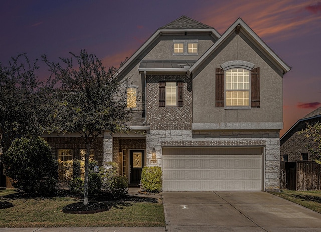 view of front facade with a garage, stone siding, a standing seam roof, and stucco siding