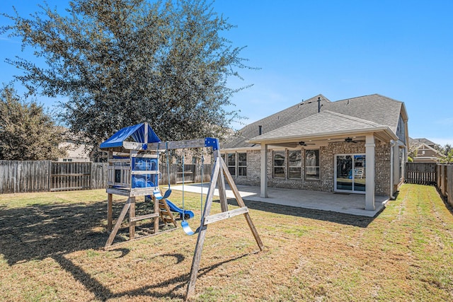 view of playground with a ceiling fan, a fenced backyard, a lawn, and a patio