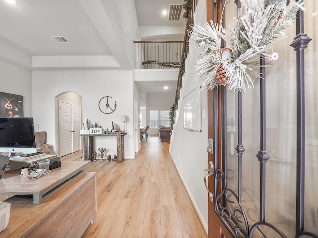 foyer entrance with a high ceiling and light hardwood / wood-style floors