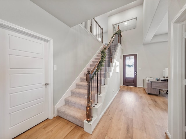 foyer featuring light hardwood / wood-style floors and a towering ceiling