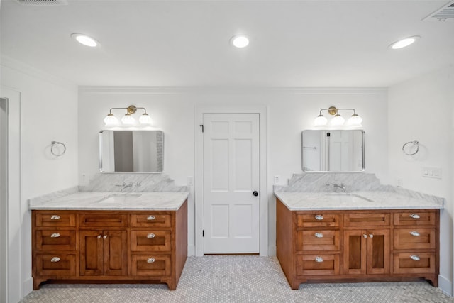 full bath with a sink, two vanities, and recessed lighting