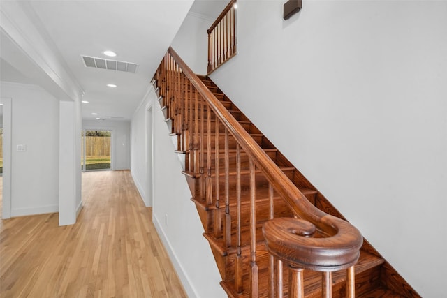 stairway featuring baseboards, visible vents, wood finished floors, crown molding, and recessed lighting