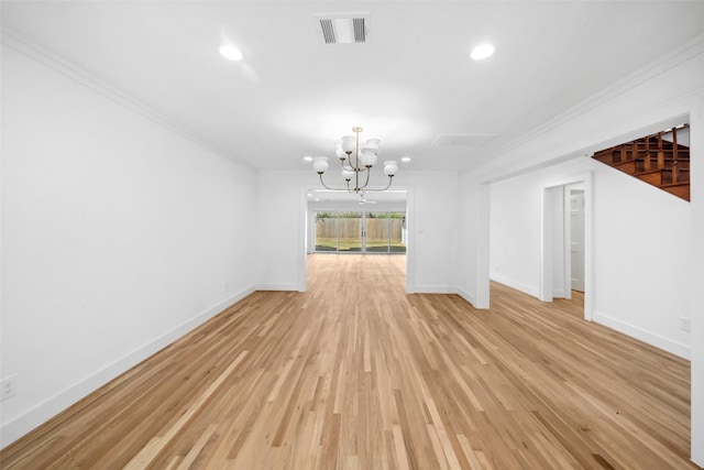 spare room with crown molding, visible vents, baseboards, light wood finished floors, and an inviting chandelier