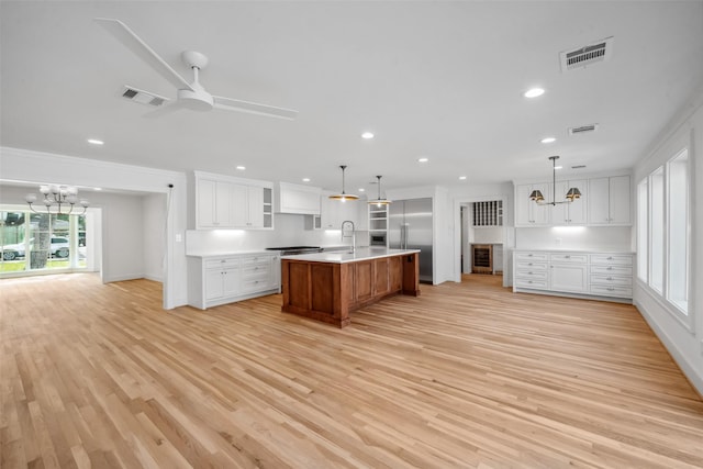 kitchen with appliances with stainless steel finishes, light countertops, visible vents, and a sink