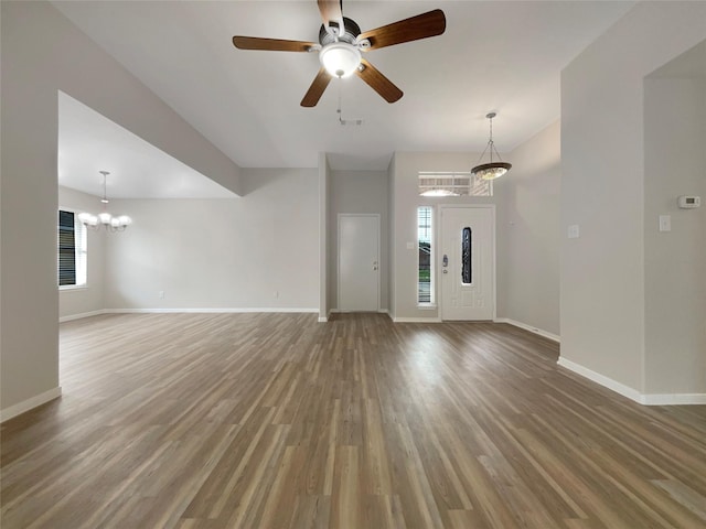 unfurnished living room with hardwood / wood-style flooring and ceiling fan with notable chandelier