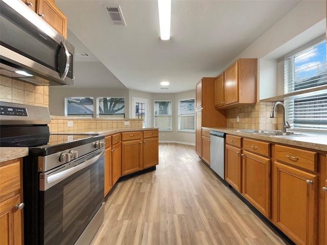 kitchen featuring light hardwood / wood-style floors, appliances with stainless steel finishes, sink, and plenty of natural light