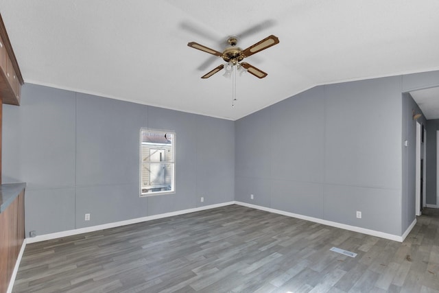 additional living space featuring lofted ceiling, visible vents, ceiling fan, wood finished floors, and baseboards