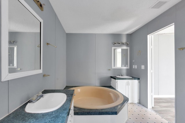 full bath featuring visible vents, two vanities, a sink, and tile patterned floors