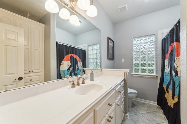 bathroom featuring plenty of natural light, vanity, tile patterned flooring, and toilet