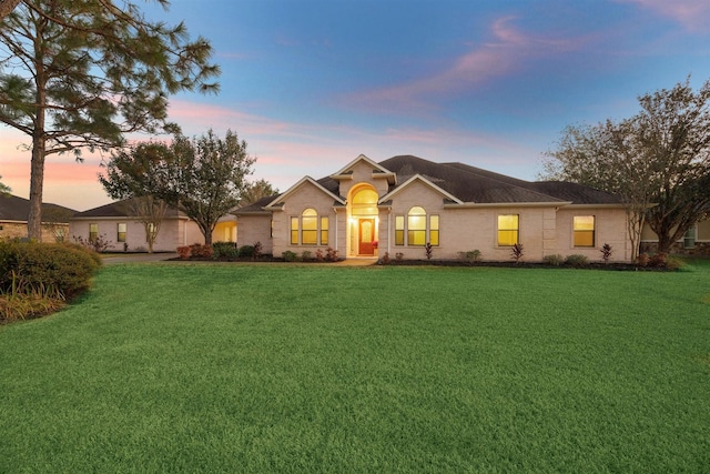 ranch-style home with a yard