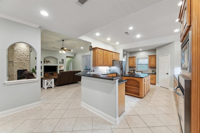 kitchen featuring a kitchen island, light tile patterned flooring, stainless steel appliances, and kitchen peninsula