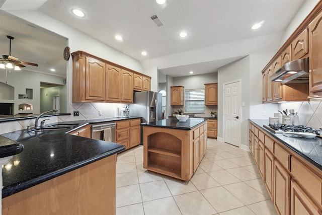 kitchen with kitchen peninsula, a kitchen island, sink, appliances with stainless steel finishes, and decorative backsplash