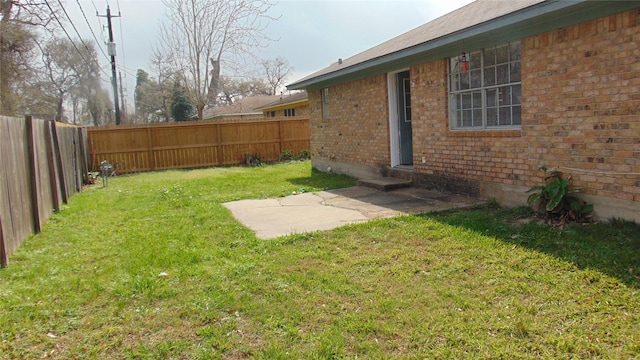 view of yard featuring entry steps and a fenced backyard