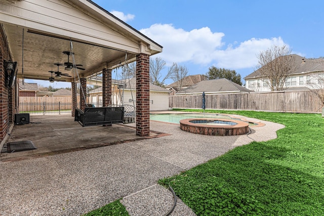 view of patio / terrace featuring a fenced backyard, a ceiling fan, and an in ground hot tub