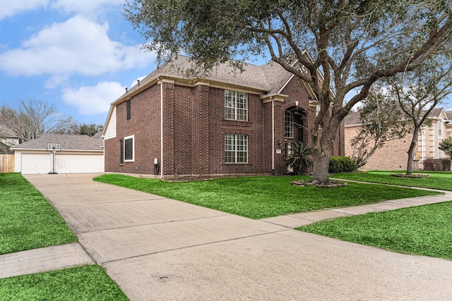 traditional home with brick siding, a front yard, and a detached garage