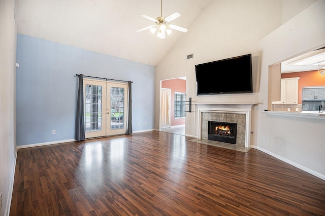 unfurnished living room with dark wood-style floors, french doors, visible vents, a high end fireplace, and baseboards