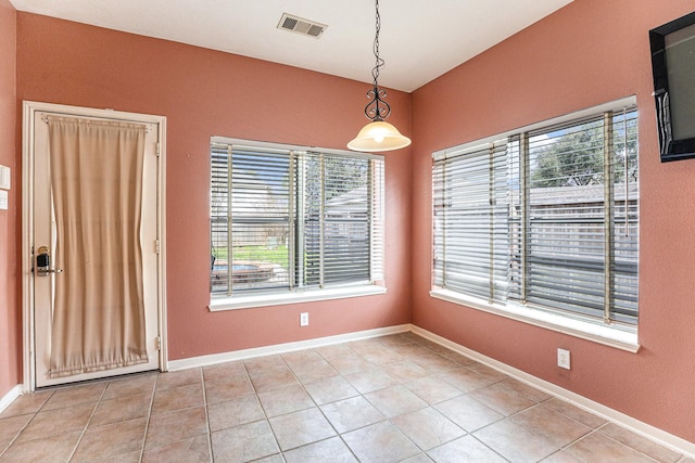 unfurnished room featuring light tile patterned floors, visible vents, and baseboards