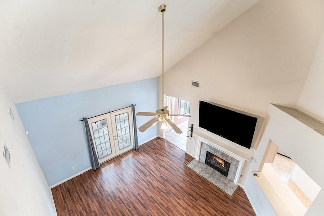 unfurnished living room with dark wood-style floors, visible vents, a premium fireplace, a ceiling fan, and baseboards