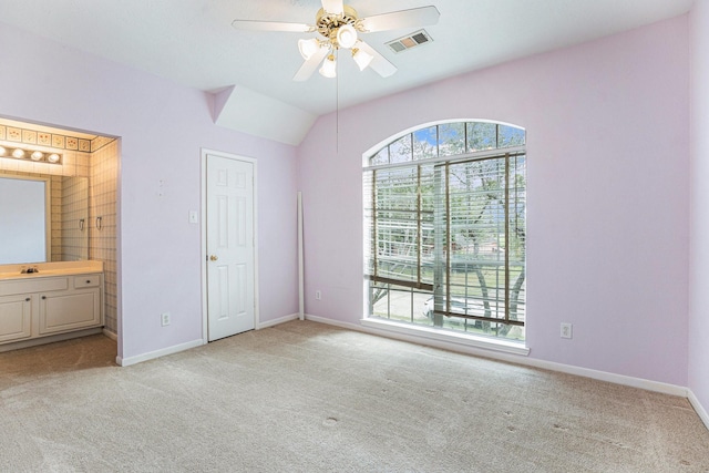 unfurnished bedroom featuring connected bathroom, light colored carpet, a sink, visible vents, and baseboards