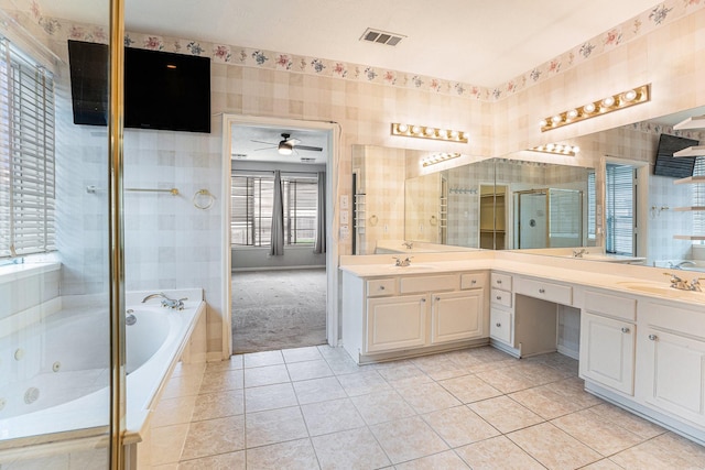 bathroom featuring a sink, a jetted tub, tile patterned floors, and wallpapered walls