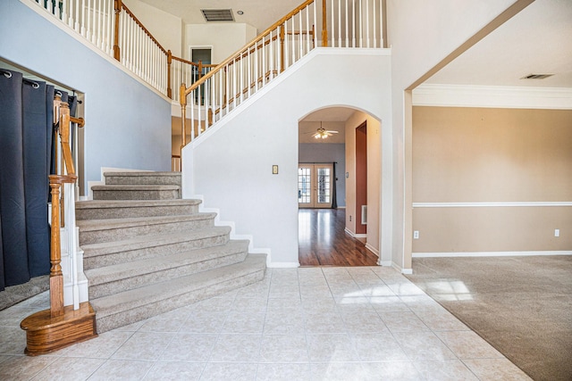 entryway with arched walkways, visible vents, and baseboards