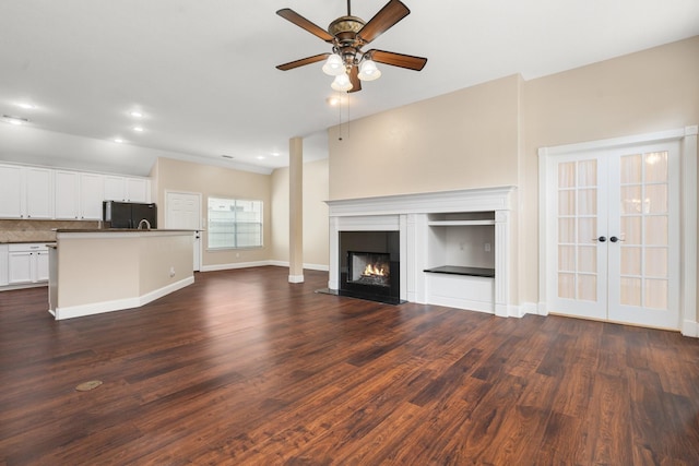 unfurnished living room featuring french doors, dark wood-type flooring, and ceiling fan