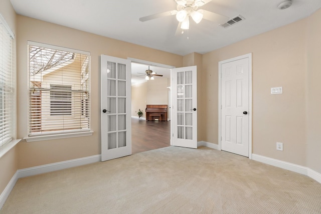 empty room featuring carpet, french doors, and ceiling fan