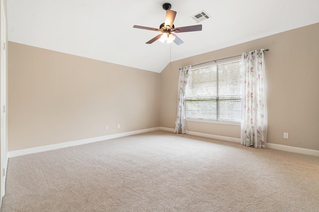 spare room with light carpet, vaulted ceiling, and ceiling fan