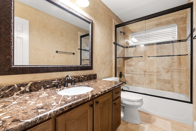 full bathroom featuring enclosed tub / shower combo, vanity, and toilet