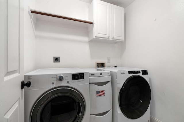 washroom with cabinets and washing machine and clothes dryer