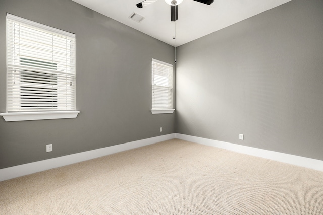 carpeted spare room with ceiling fan