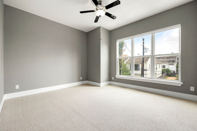 carpeted spare room featuring ceiling fan