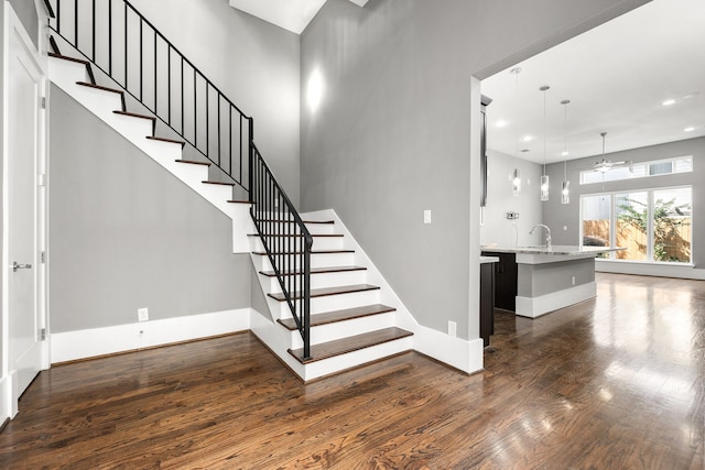 staircase featuring recessed lighting, baseboards, ceiling fan, and wood finished floors