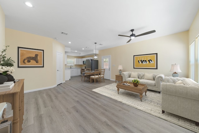 living area with light wood finished floors, recessed lighting, visible vents, a ceiling fan, and baseboards