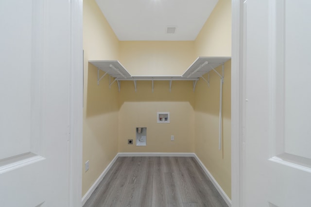 clothes washing area with light wood-type flooring, laundry area, hookup for a washing machine, and baseboards