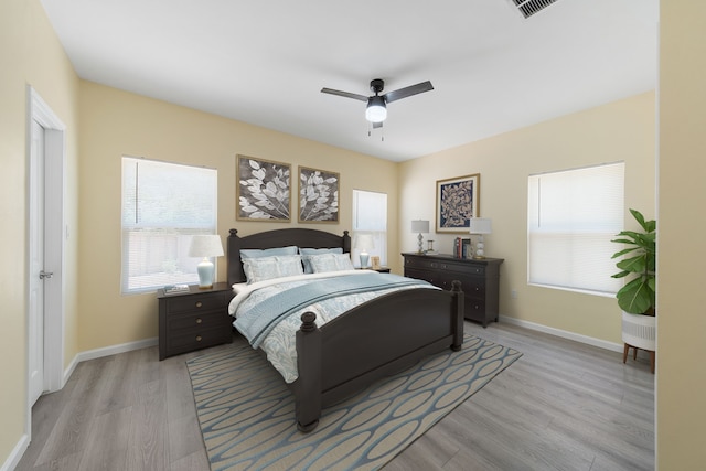 bedroom featuring light wood-style flooring, visible vents, baseboards, and a ceiling fan