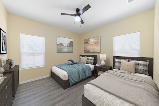 bedroom featuring light wood-style flooring, baseboards, and ceiling fan