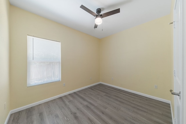 unfurnished room featuring ceiling fan, baseboards, and wood finished floors