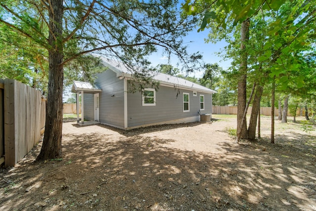 back of property with metal roof and a fenced backyard