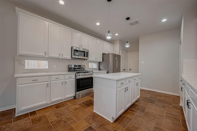 kitchen featuring appliances with stainless steel finishes, white cabinetry, a kitchen island, and decorative light fixtures