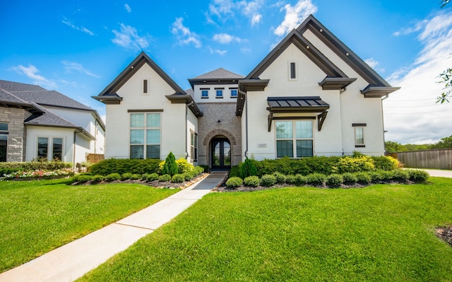 view of front of house with fence, stone siding, french doors, stucco siding, and a front yard