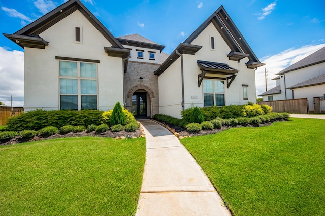 view of front of home featuring stone siding, a front lawn, fence, and stucco siding