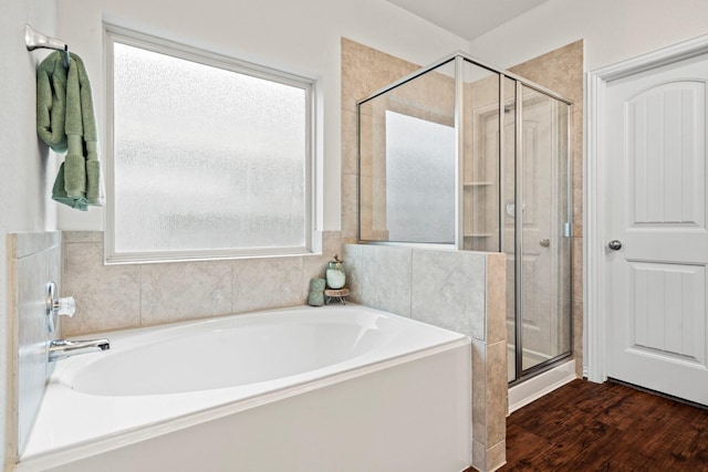 bathroom featuring wood finished floors, plenty of natural light, a shower stall, and a bath