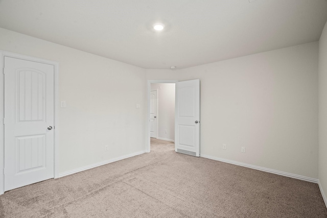 unfurnished room with carpet and baseboards