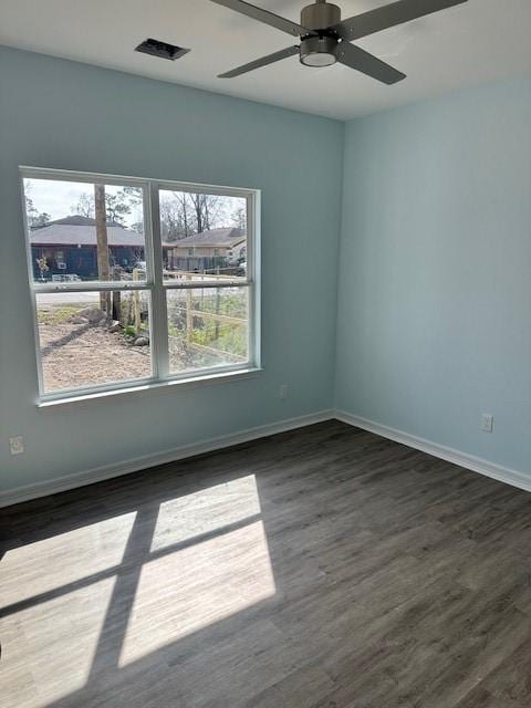 empty room with ceiling fan and dark hardwood / wood-style floors