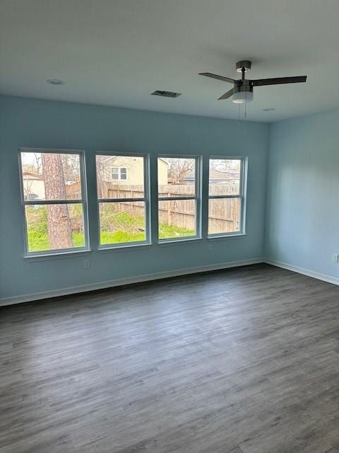 empty room with dark hardwood / wood-style floors and ceiling fan