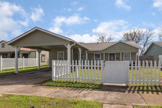 view of front of home featuring driveway, a fenced front yard, a carport, and a front yard